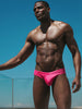 Man wearing CODE 22 ALTEA 25063 pink swim briefs, showcasing a slim fit and stylish design against a clear blue sky. CODE 22 ALTEA 25063, Herren Badehose Code 22 Kleidung & Accessoires:Herren:Herrenmode:Bademode nudosz.myshopify.com